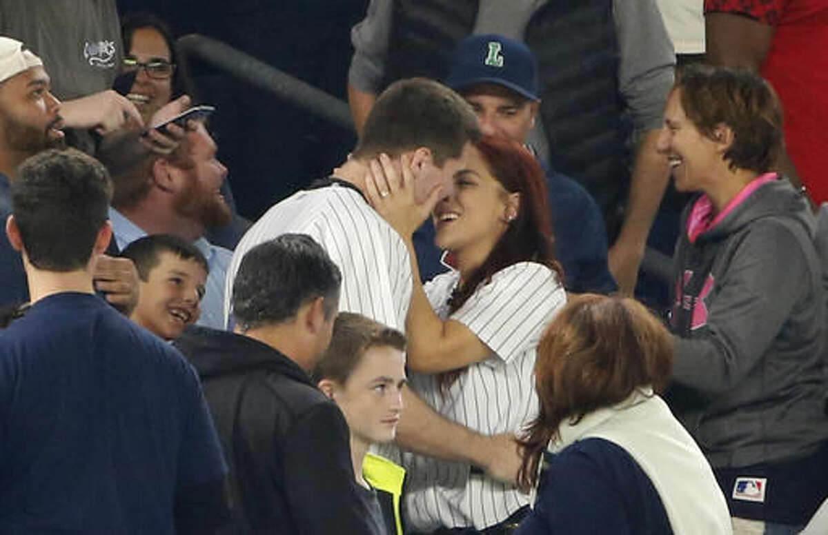 Andrew Fox and Heather Terwilliger embrace after getting engaged during a baseball game between the New York Yankees and the Boston Red Sox in New York, Tuesday, Sept. 27, 2016. (AP Photo/Kathy Willens)