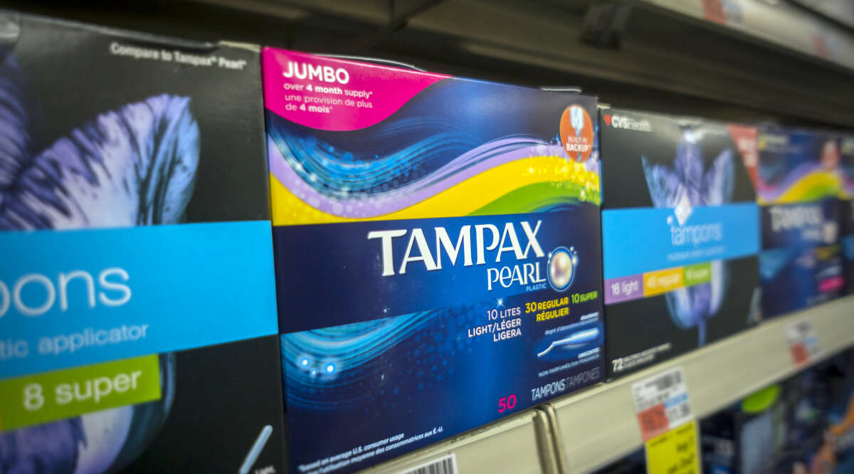 FILE-- Boxes of tampons are displayed in a pharmacy. California will extend workplace protections to 2.7 million more people who now will be able to take 12 weeks of parental leave without fear of losing their job. Other bills give diaper subsidies to parents in the welfare-to-work program, require schools with low-income students to provide free tampons and pads in campus bathrooms.