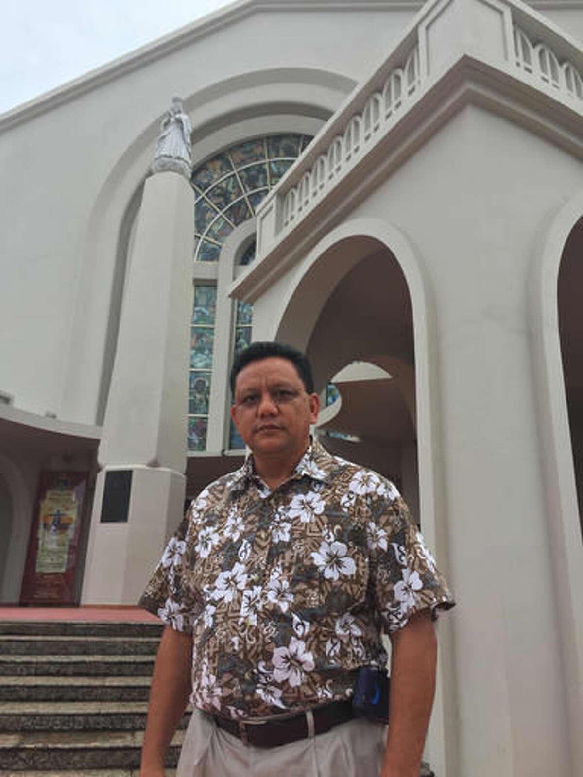 Roland Sondia, 54, stands in front of the Dulce Nombre de Maria Cathedral-Basilica in Hagatna, Guam on Friday, Sept. 23, 2016. Guam Gov. Eddie Calvo said Friday he signed a bill that would lift the statute of limitations on child sex abuse charges for civil cases, a move that Catholic leaders say could bankrupt the church in the largely Catholic U.S. territory. Sondia, who earlier this year publicly accused Archbishop Anthony Apuron of molesting him when he was a 15-year-old altar boy, said he would now file a lawsuit. (AP Photo/Grace Garces Bordallo)