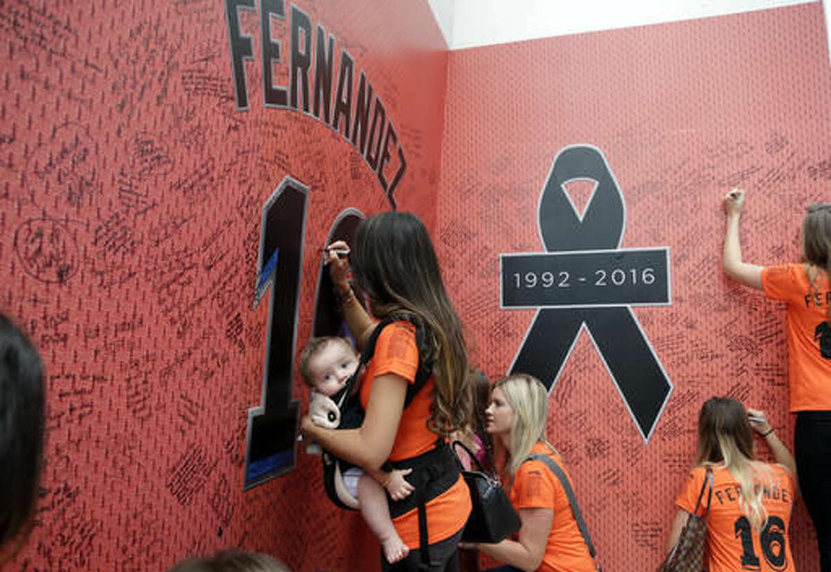 Fans sign a wall at a makeshift memorial for Miami Marlins pitcher Jose Fernandez before a baseball game between the Miami Marlins and the New York Mets , Monday, Sept. 26, 2016, in Miami. Fernandez died in a boating accident early Sunday. (AP Photo/Lynne Sladky)