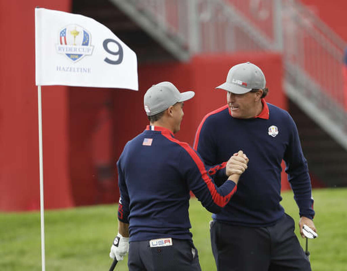 United States’ Phil Mickelson celebrates with teammate Rickie Fowler after Fowler chipped in on the ninth to win the hole during a foresomes match at the Ryder Cup golf tournament Friday, Sept. 30, 2016, at Hazeltine National Golf Club in Chaska, Minn. (AP Photo/David J. Phillip)