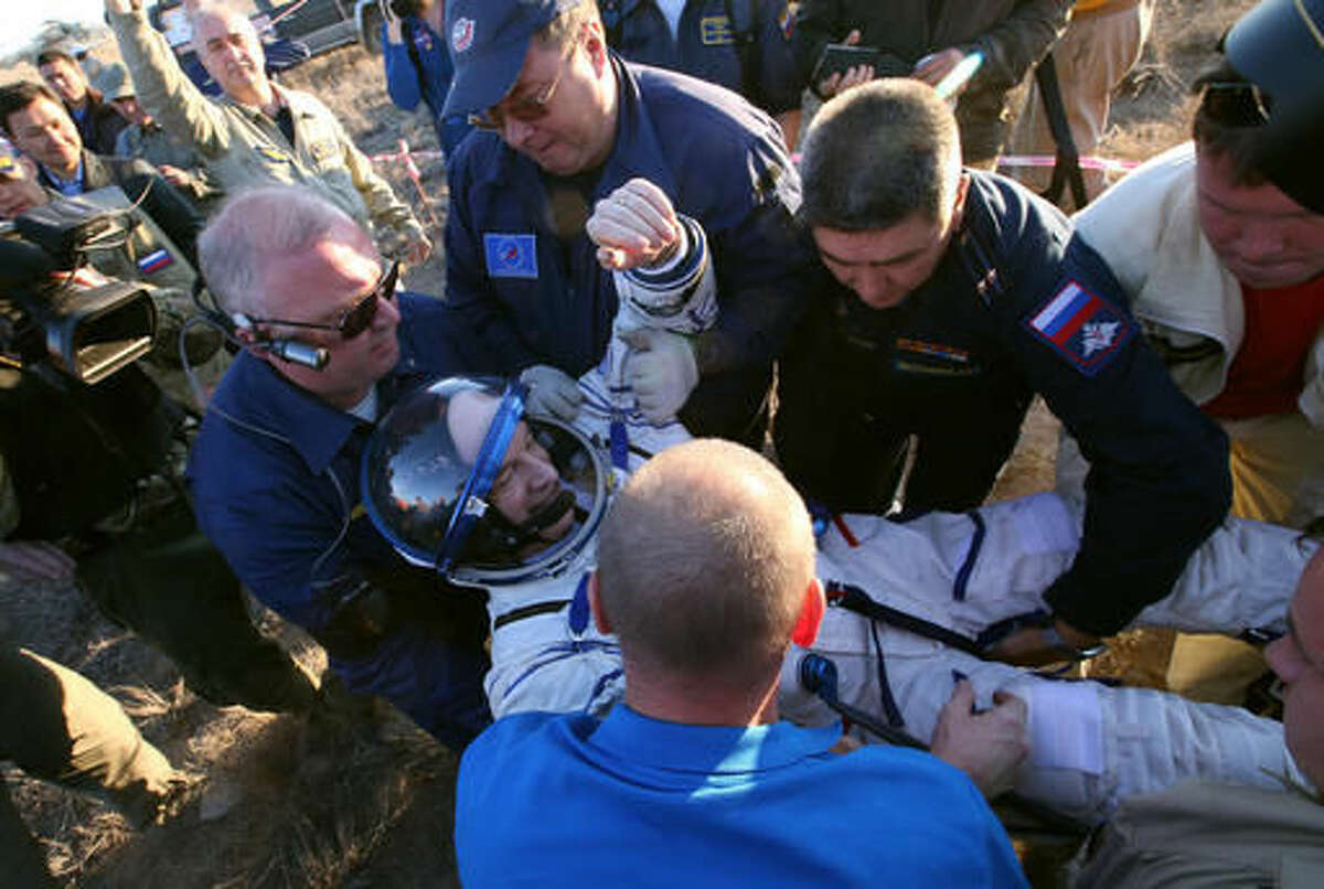 Ground personnel help US NASA astronaut Jeffrey Williams to get out of the Soyuz TMA-20M spacecraft a few moments after they landed in a remote area near the town of Zhezkazgan, Kazakhstan, Wednesday, Sept. 7, 2016. The record-setting American and two Russians landed safely back on Earth Wednesday after a six-month mission aboard the International Space Station. (Maxim Shipenkov/Pool Photo via AP)
