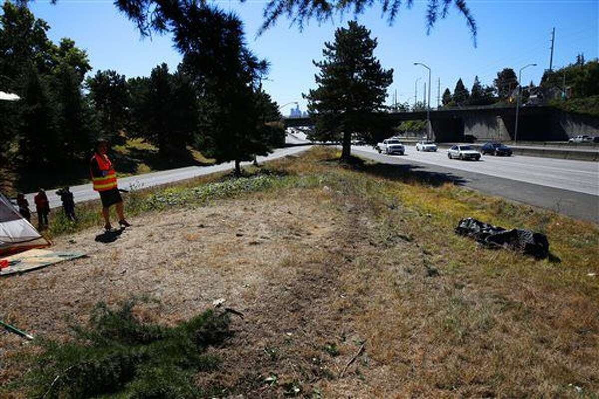 CORRECTS TRANS REFERENCE TO WASEA - Tire tracks are visible through the center of the embankment where a car ran into a homelessness encampment, killing one, near the 50th St NE Interstate 5 off-ramp in the University District early Monday, Sept. 12, 2016. (Genna Martin/seattlepi.com via AP)