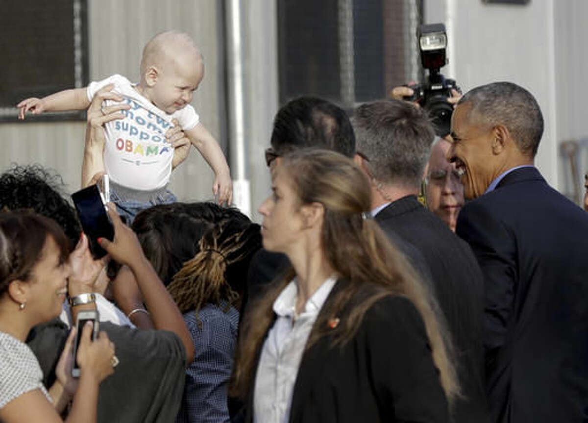 President Barack Obama smiles at a baby as he greets people as he arrives on Air Force One at John F. Kennedy International Airport, in New York, N.Y., Sunday, Sept. 18, 2016, en route to a Democratic National Committee event. (AP Photo/Carolyn Kaster)