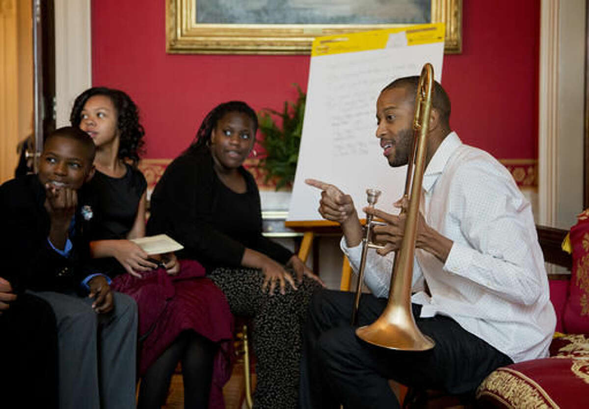 FILE - In this Oct. 14, 2015, file photo, musician Troy "Trombone Shorty" Andrews, right, of New Orleans mentors middle school children from the Washington area during a student workshop in the Red Room of the White House in Washington. The Heinz Family Foundation announced winners of the Heinz Awards on Wednesday, Sept. 14, 2016, naming musician Troy "Trombone Shorty" Andrews and others as winners. (AP Photo/Manuel Balce Ceneta, File)