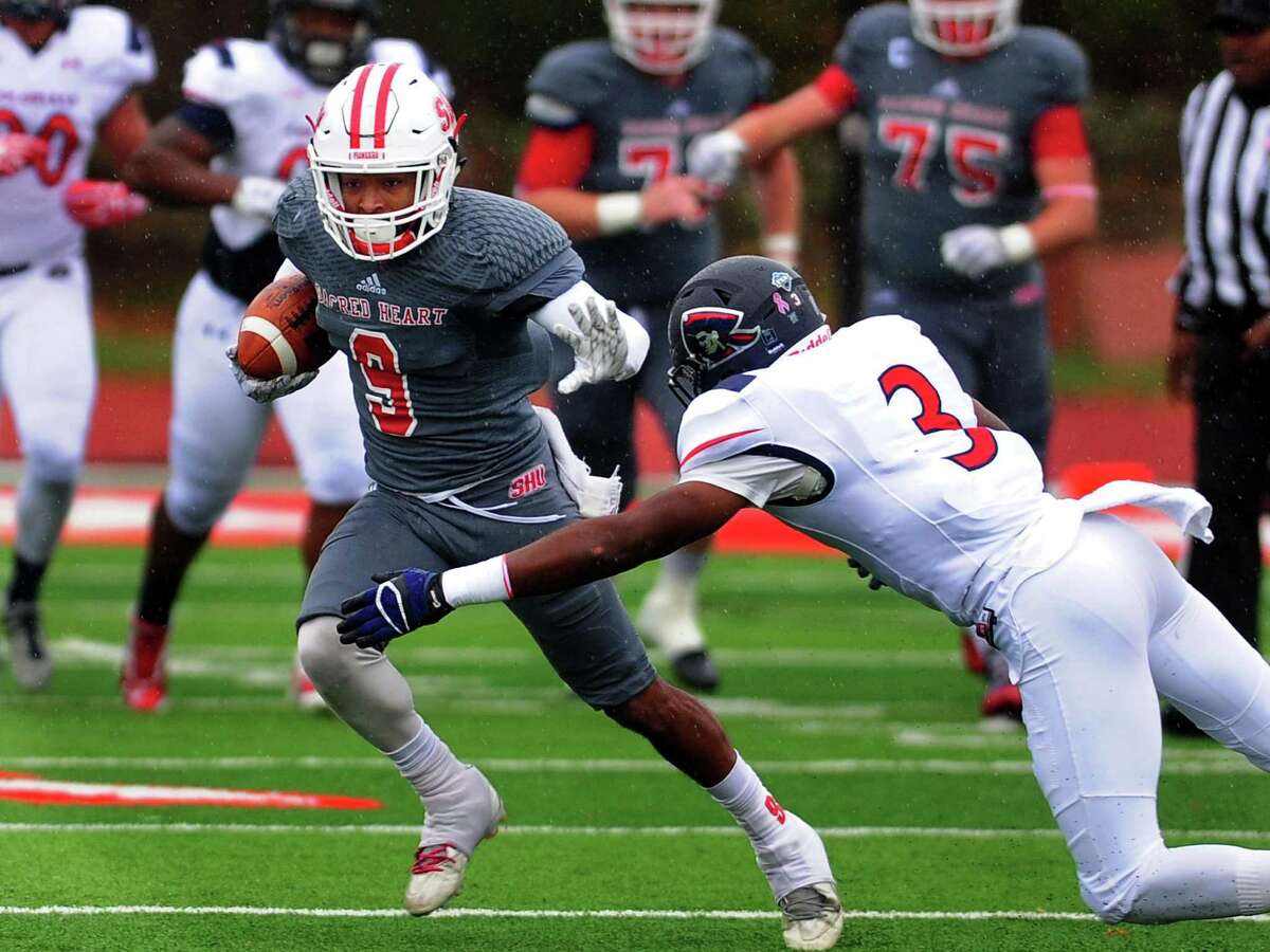 Sacred Heart’s Moses Webb, left, evades Robert Morris’ Drew Allen during college football action in Fairfield on Saturday.