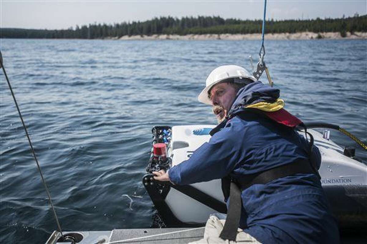 In this Aug. 24, 2016 photo, after a successful retrieval of decades-old temperature gauges from the lake bottom, senior electronics engineer of Global Foundation for Ocean Exploration Dave Wright prepares Yogi for another dive on Yellowstone Lake, in Yellowstone National Park, in Wyo. The remote-operated vehicle is submersible to depths up to 1,500 meters - nearly 5,000 feet - which means the foundation could use it to explore any lake in the United States. (Ryan Dorgan/Jackson Hole News & Guide via AP)