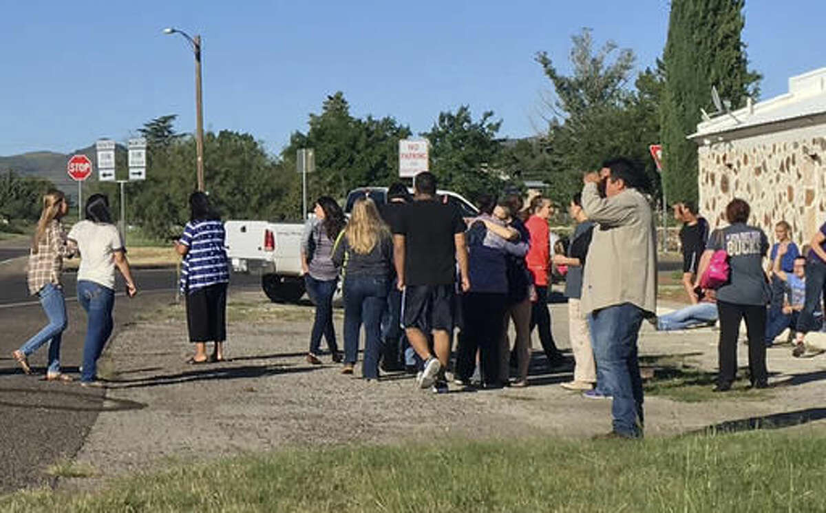 In this photo provided by the Alpine Avalanche, people gather near the Alpine High School school campus after a shooting, in Alpine, Texas, Thursday, Sept. 8, 2016. A student died of an apparent self-inflicted gunshot wound, the Brewster County sheriff said. (Gail Yovanovich/Alpine Avalanche via AP)