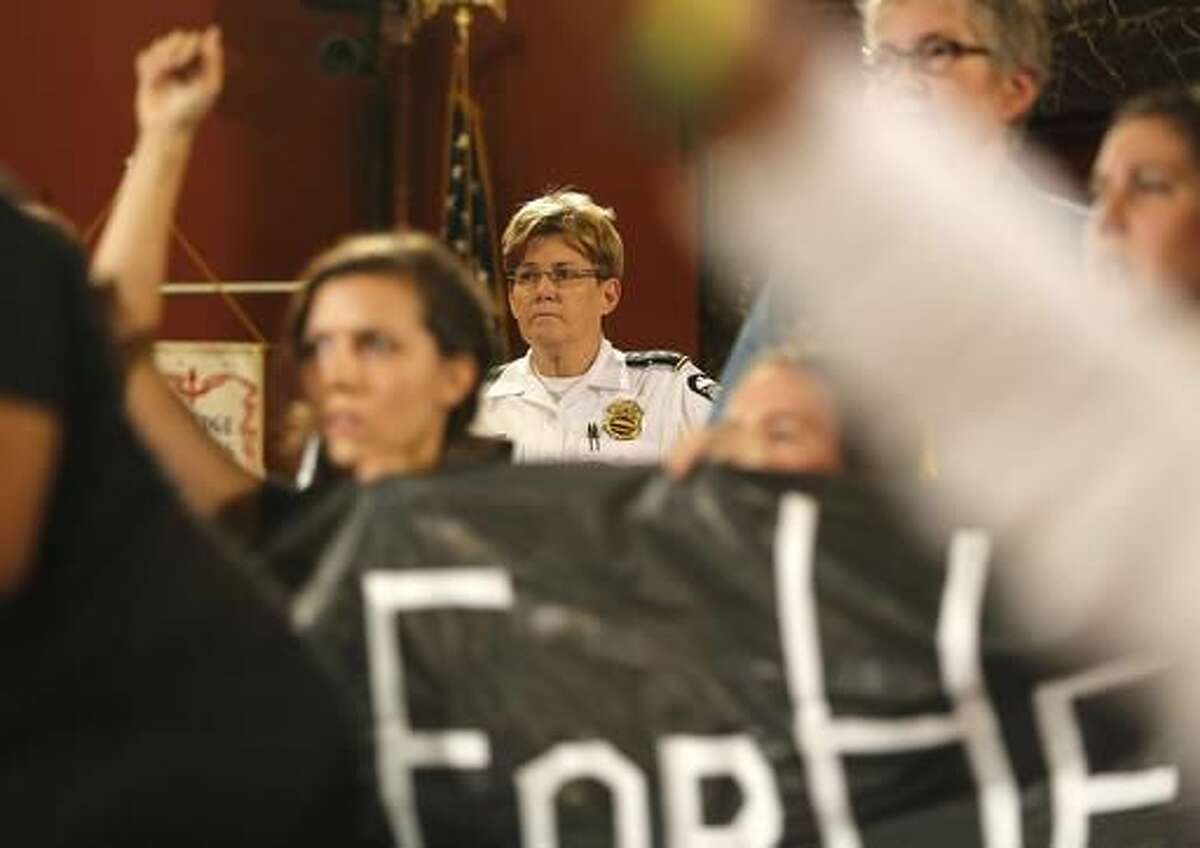 Columbus police chief Kim Jacobs watches as protesters interrupt the Columbus City Council meeting on Monday, Sept. 26, 2016. Dozens of demonstrators protesting the fatal police shooting of a 13-year-old black boy brought the meeting to a halt as they called for an independent investigation. (Jonathan Quilter/The Columbus Dispatch via AP)