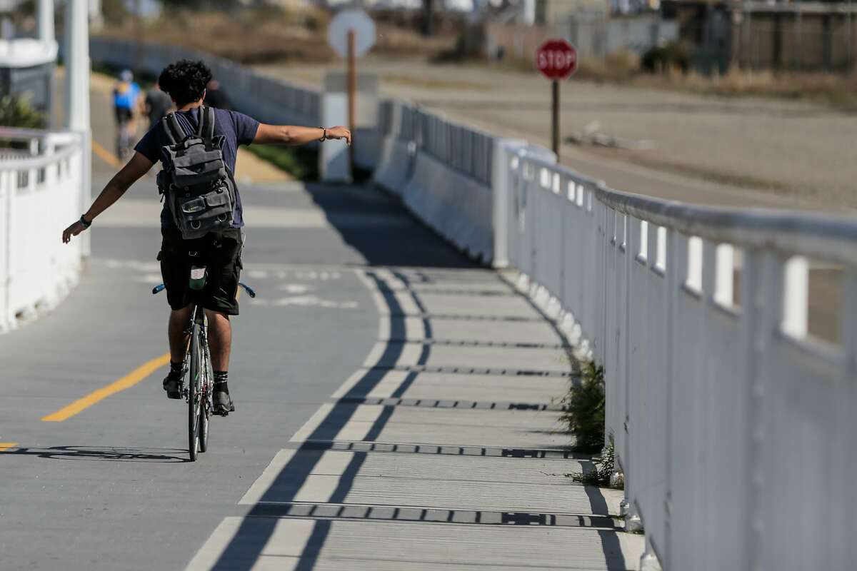 A man balanced himself on his bike, while riding along the 4.5-mile San Francisco-Oakland Bay Bridge path, which opened a new path today, connecting the Emeryville path with the new endpoint on Yerba Buena Island, in Oakland, California, on Sunday, Oct. 23, 2016.