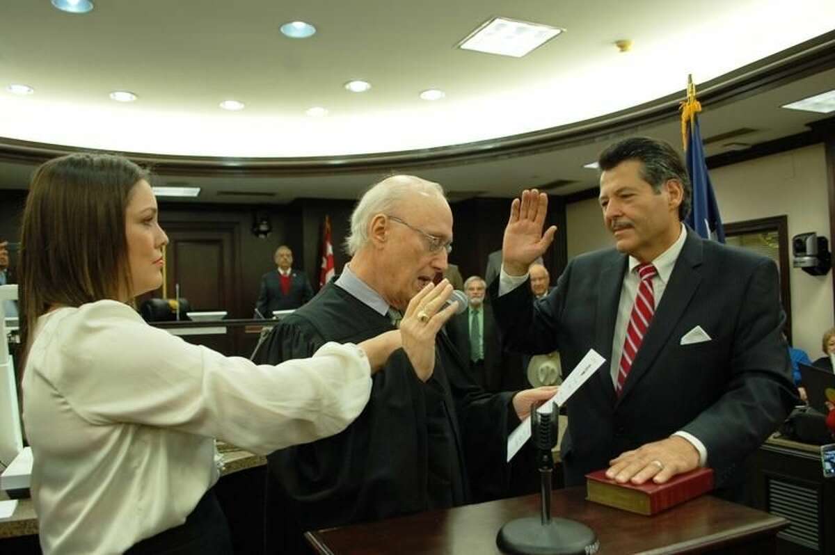 The new Laredo mayor, Pete Saenz, right, takes the oath of office Wednesday at City Hall Council Chambers. U.S. District Judge George Kazen administered the oath of office. Saenz's daughter, Monica Saenz-Vigil, holds the microphone. READ MORE: http://bit.ly/1Ev9xAu (Courtesy photo/City of Laredo)