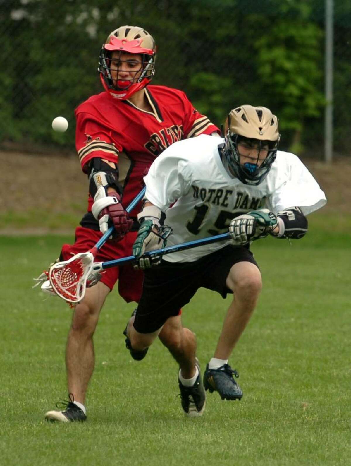 Stratford No. 21 Vinny Valente trips up Notre Dame of Fairfield No. 15 Steve Meyer during high school lacrosse action Monday, May 17th, 2010, in Fairfield.