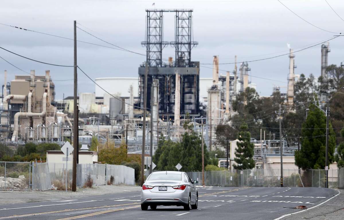 A car drives on San Pablo Avenue towards the Phillips 66 refinery, which borders the Bayo Vista neighborhood in Rodeo, Calif. on Tuesday, Oct. 25, 2016.