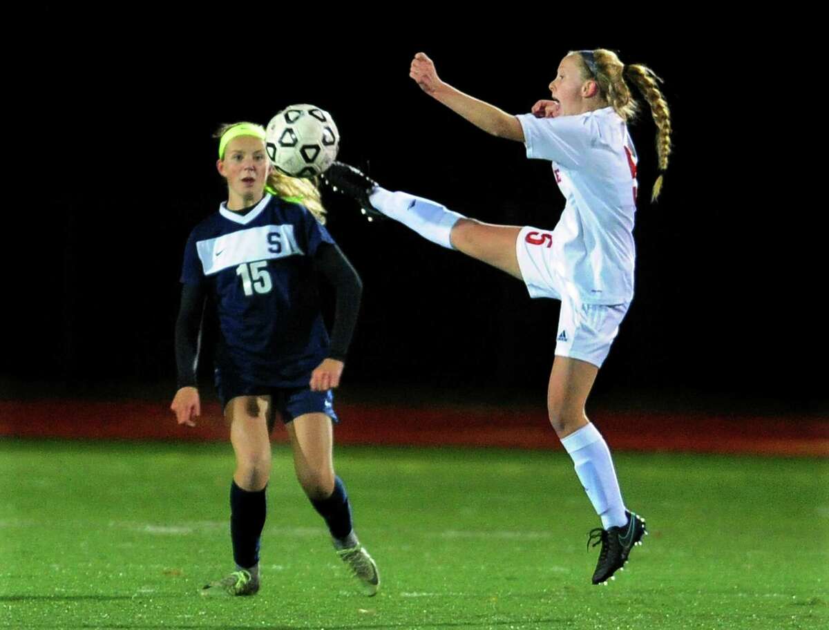 Fairfield Warde's Lauren Tangney leaps in to intercept the ball away from Staples Olivia Ronca during girls soccer action in Fairfield, Conn., on Tuesday Oct. 25, 2016.