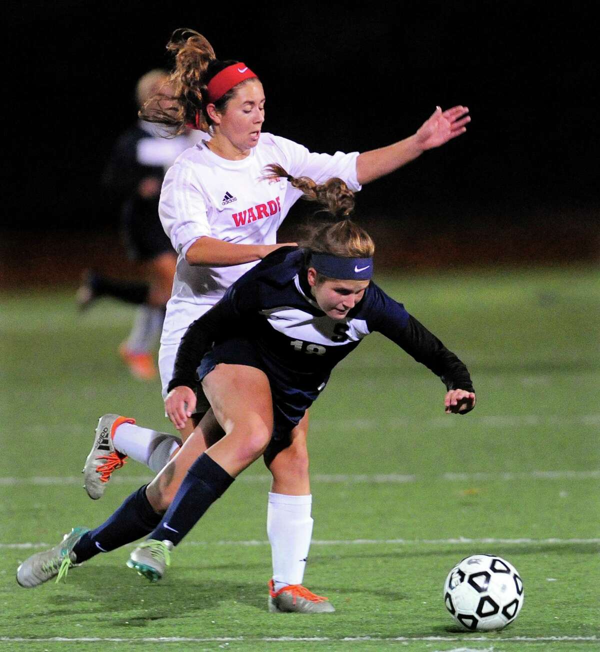 Staples Morgan McWhirter falls in front of Fairfield Warde's Alexa Montani during girls soccer action in Fairfield, Conn., on Tuesday Oct. 25, 2016.