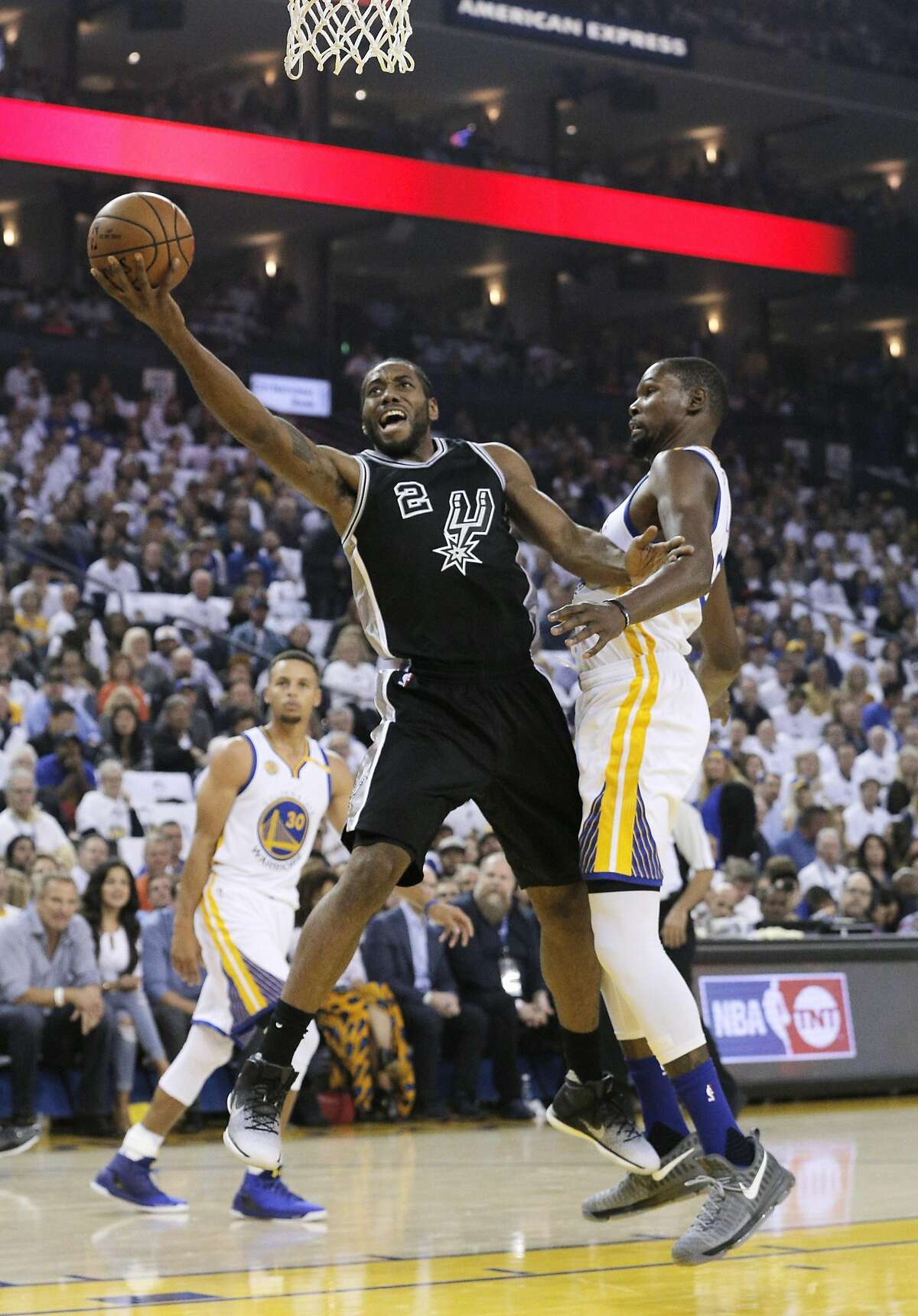 Kawhi Leonard (2) drives to the basket past Kevind Durant (35) in the first half as the Golden State Warriors played the San Antonio Spurs in their season opener at Oracle Arena in Oakland, Calif., on Tuesday, October 25, 2016.