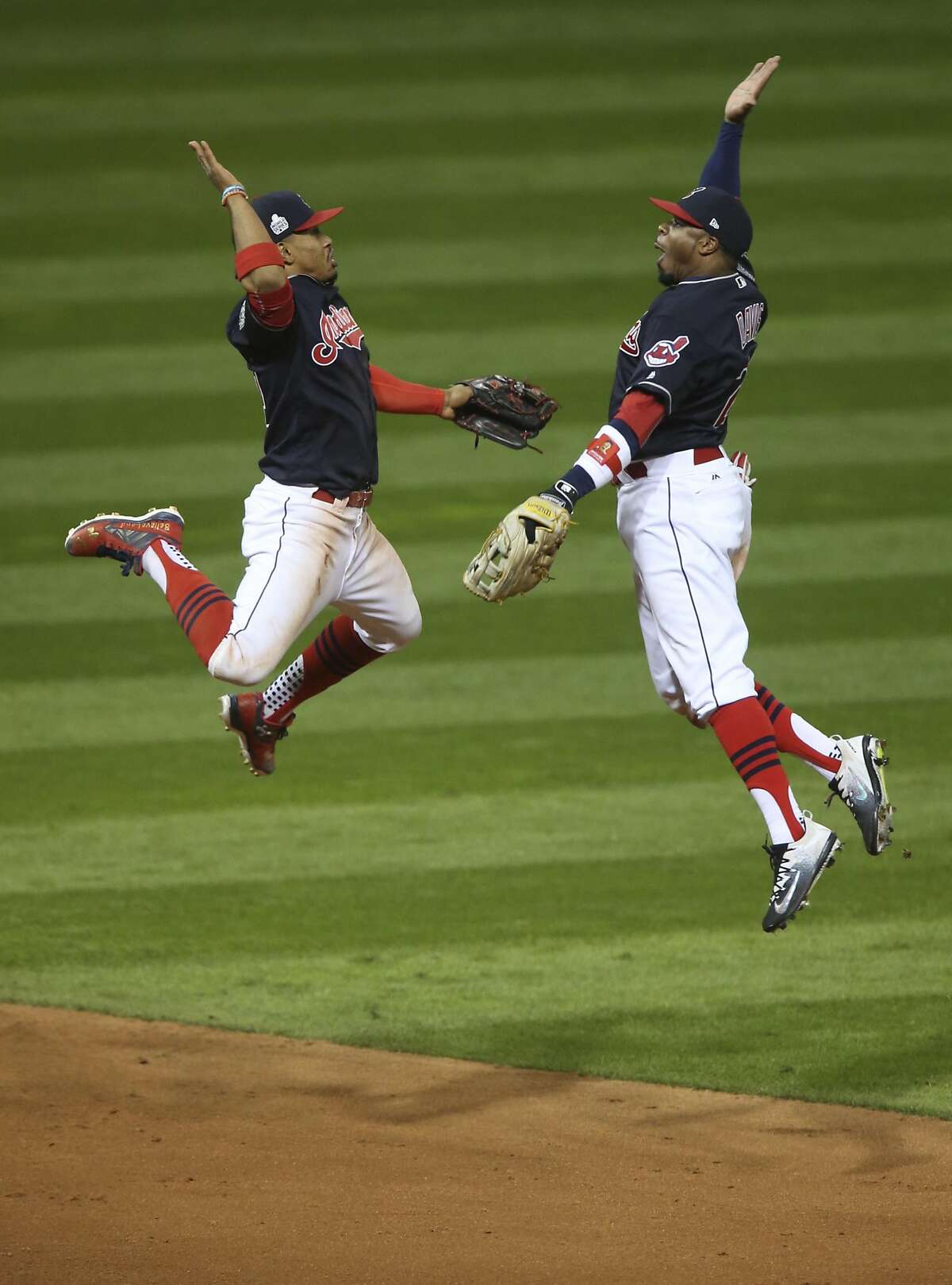 Cleveland Indians Francisco Lindor (L) and Rajai Davis leap to