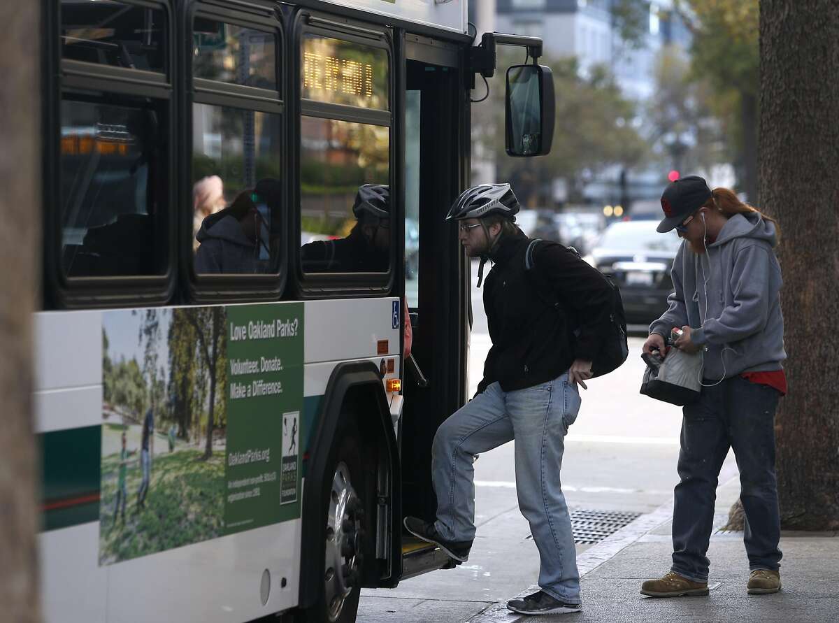 In this file photo, passengers board an AC Transit bus on Broadway in Oakland.