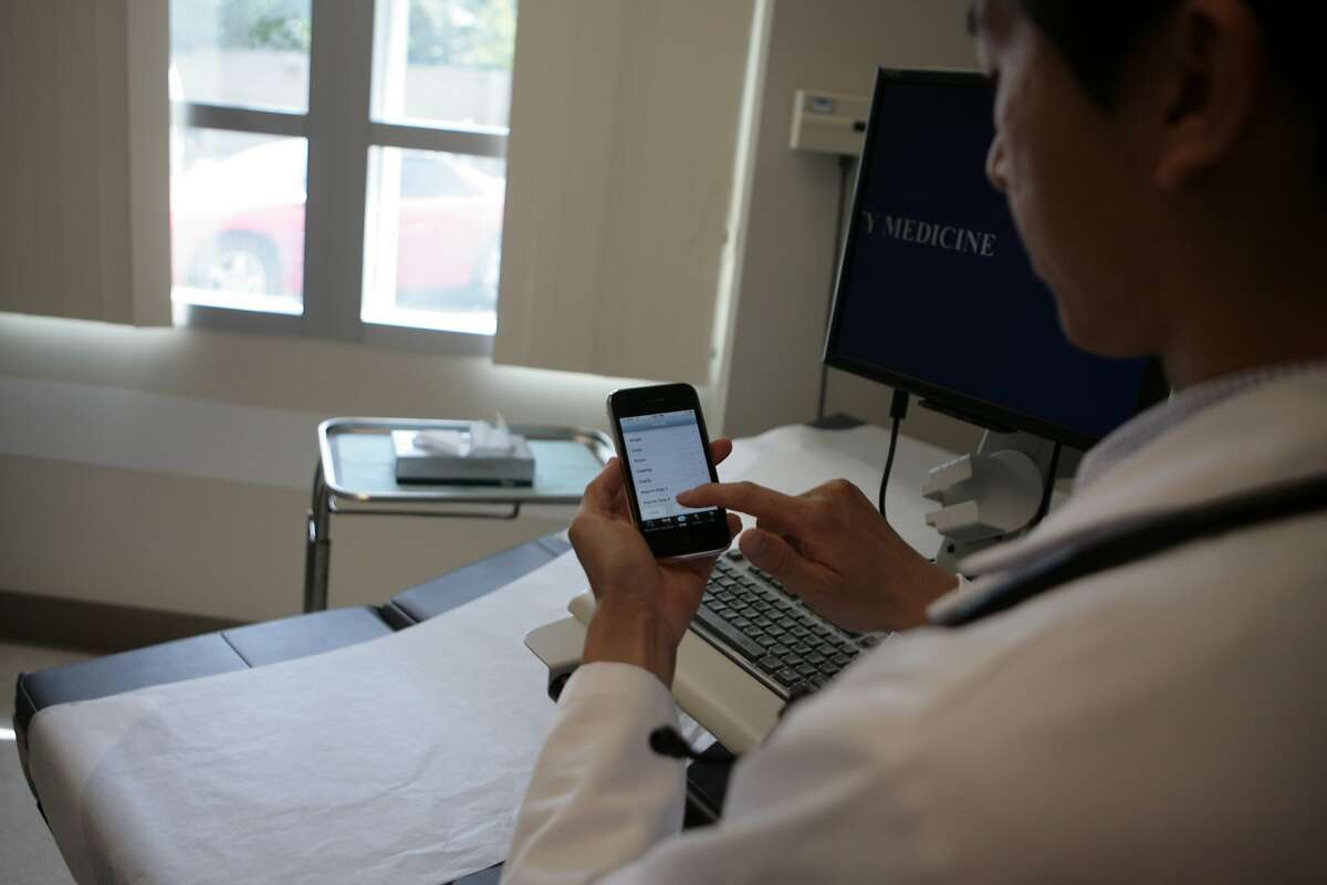 Dr. Steven Chang uses his the iPhone to access the application ePocrates in an exam room to receive updated drug information on August 5, 2008, Sacramento, Calif. Dr. Steven Chang, resident in primary care at UC Davis Medical Center, is responsible for ePocrates being on Apple's iPhone list of applications. This application allows doctors to get updated information on drugs on Tuesday, August 5, 2008, Sacramento, Calif. Photo by Christina Izzo / The Chronicle