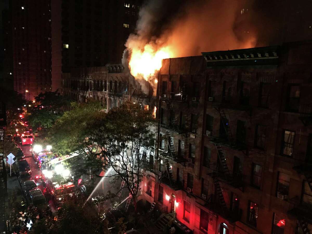 Firefighters work to put out a blaze at an apartment building on the Upper East Side in New York on Thursday, Oct. 27, 2016. The flames quickly spread throughout the building and were shooting out the roof at one point, sending burning embers onto nearby buildings. (Matt Bonaccorso via AP) ORG XMIT: NY110