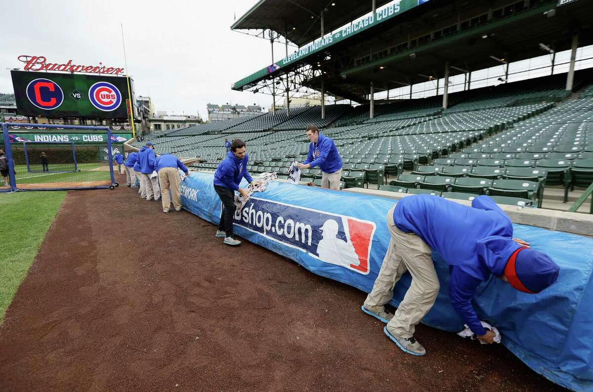 CHICAGO, IL - OCTOBER 27: Members of the grounds crew clean off a tarp before batting practice at Wrigley Field on October 27, 2016 in Chicago, Illinois. The Chicago Cubs play the Cleveland Indians in game 3 of the World Series on Friday, October 28.