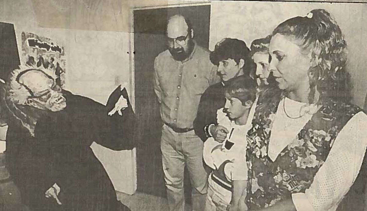 Death monitor at the reality-based haunted house, Tyron Neveaux, gestures as he tells of how he took the life of a cheerleader through a drug overdose to Hellhouse visitors, from left, David mack, Cheryl Mack, daniel Mack, Erin Mack and Anita Simon. Photo taken Oct. 30, 1993