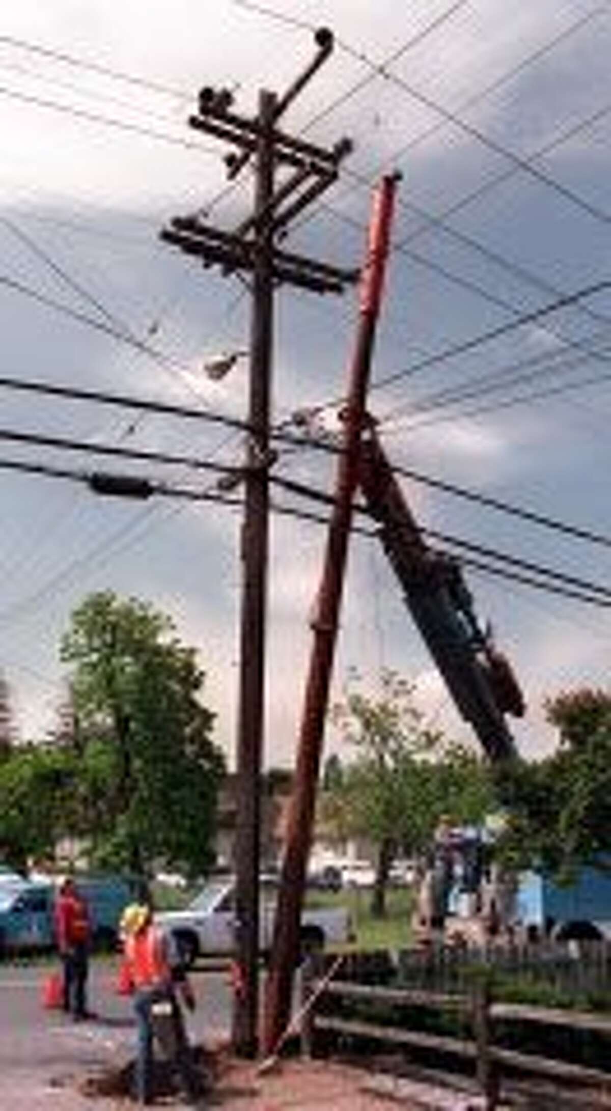 POLES/C/04MAY95/BU/JLTelfer PG&E line workers Doug Bock and Jeff Rachel keep tabs on the alignment as boom operator John Sobelman finesses a replacement power pole into place among the active power and phone lines on a damaged power pole. PG&E is doing a statewide program to upgrade its $3 billion worth of power poles. � Imola and Wilkins - Napa, CA