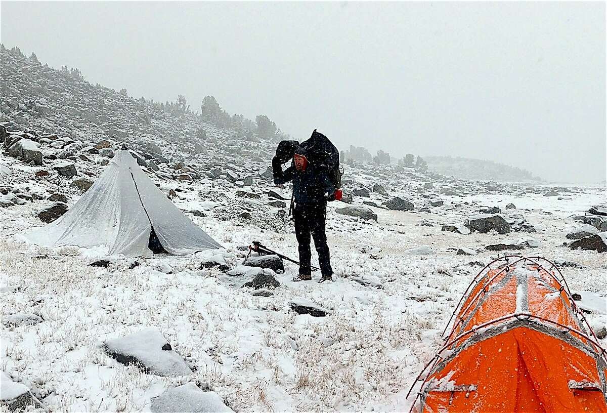 SF Chronicle outdoors writer Tom Stienstra,�on wilderness trek above treeline at 12,500 feet in Yosemite National Park, breaks camp�during October's first snow to hit the high Sierra Nevada