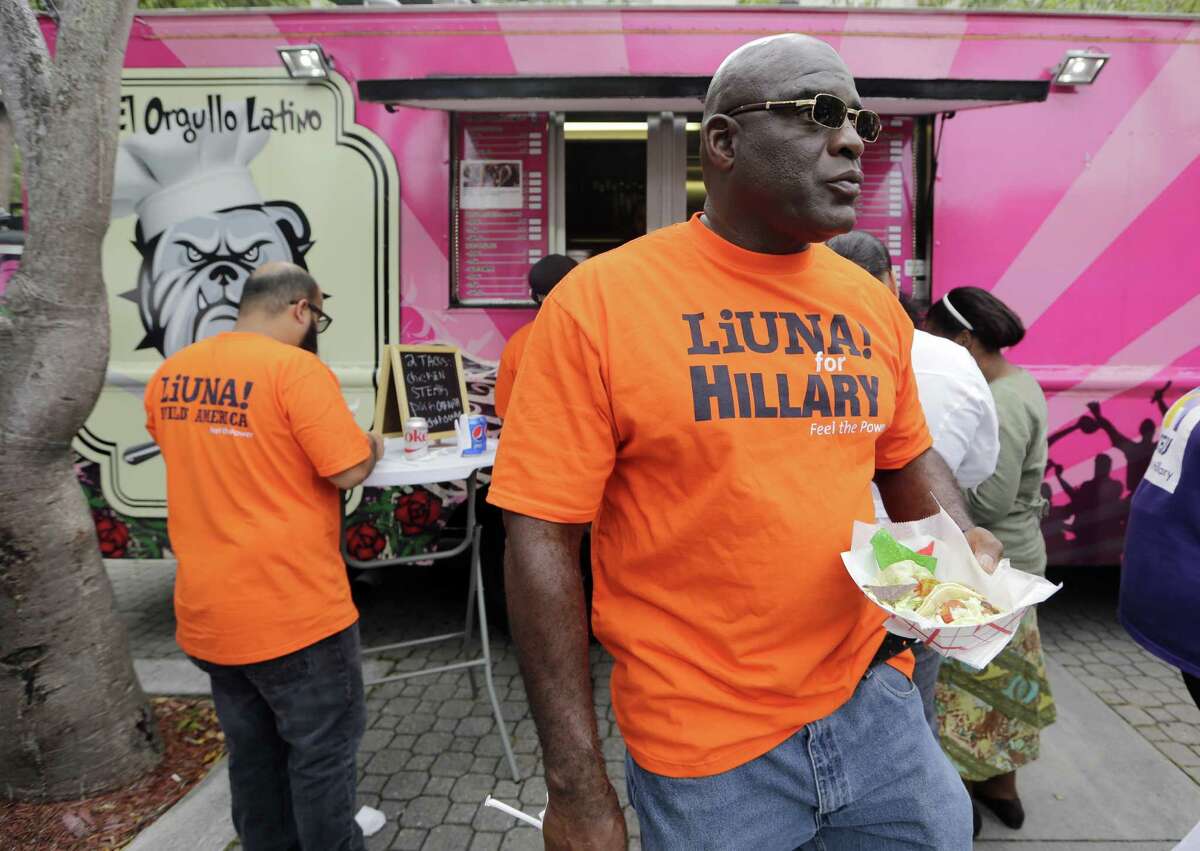 Supporters of Democratic presidential candidate Hillary Clinton get free tacos from a taco truck at an early voting celebration in Miami. A reader expresses concern over calls by Republican candidate Donald Trump for supporters to monitor polling sites.
