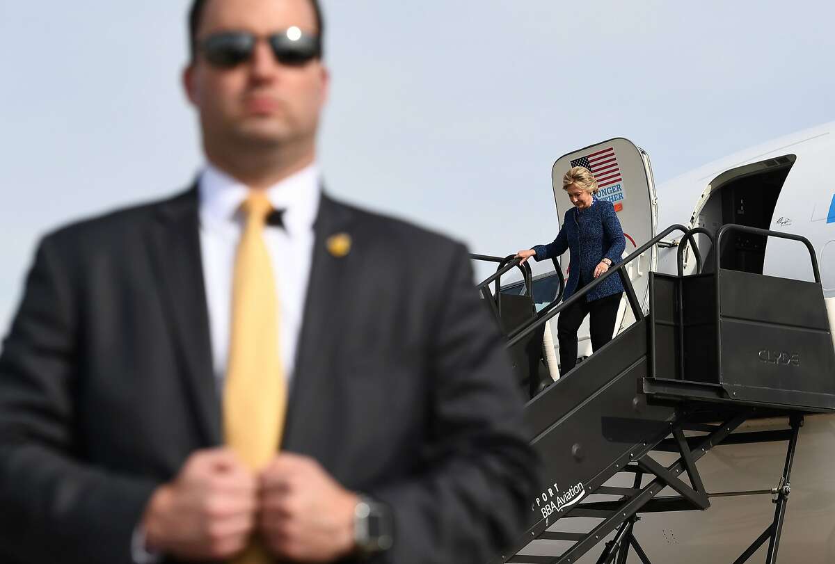 US Democratic presidential nominee Hillary Clinton waves as she walks off her campaign plane in Cedar Rapids, Iowa, on October 28, 2016. / AFP PHOTO / Jewel SAMADJEWEL SAMAD/AFP/Getty Images