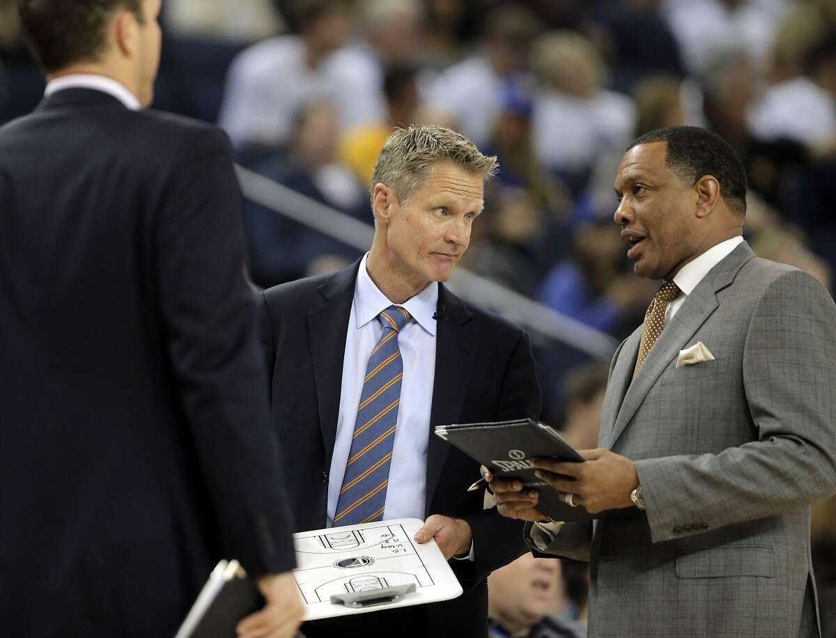 Warriors Head Coach Steve Kerr confers with coach Alvin Gentry in the first half. The Golden State Warriors played the Los Angeles Clippers at Oracle Arena in Oakland, Calif., on Sunday, March 8, 2015.