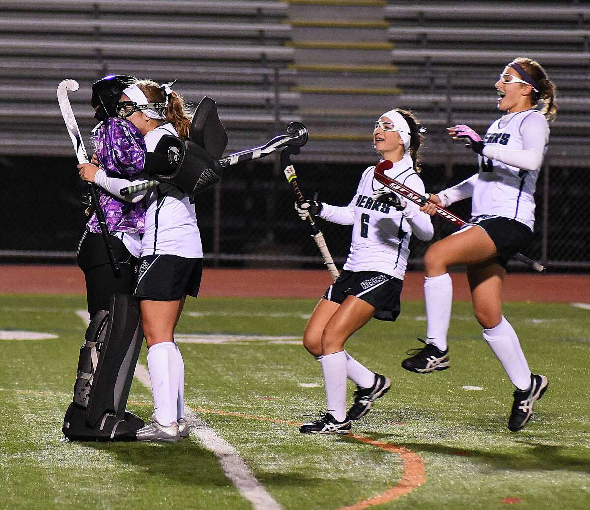 Norwalk field hockey goalie Sam Troetti, left, is embraced by teammates, from second from left, Isabell Nees, Victoria Chiappetta and Frances Mirabile at the end of the Bears' 2-1 win over New Canaan in Friday's FCIAC field hockey quarterfinal at Testa Field in Norwalk.