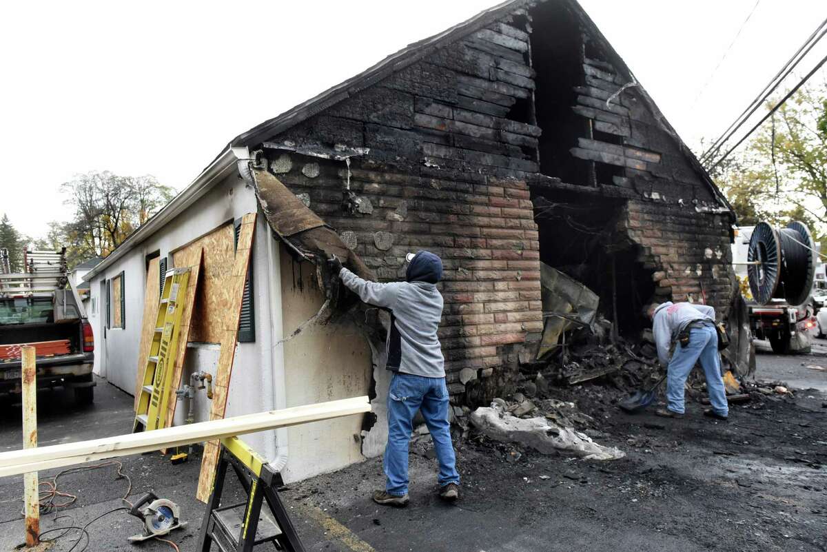 Brothers Andrew Klouse, left, and Anthony Klouse, who are friends with the tavern owner, clean up fire debris on Saturday, Oct. 29, 2016, at Blessings Tavern in Colonie, N.Y. (Cindy Schultz / Times Union)