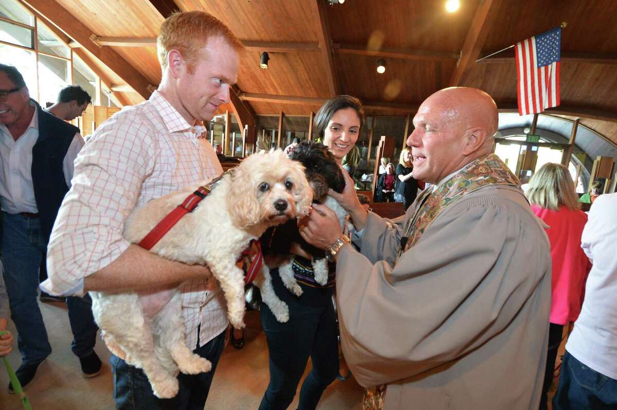 Robert Lounihan and wife Maura Bonanni with their Cavacho's Lacey and Max as Pastor John Livinstion blesses the animals during a special Sunday service at the United Church of Rowayton on Sunday October 30, 2016 in Norwalk Conn.
