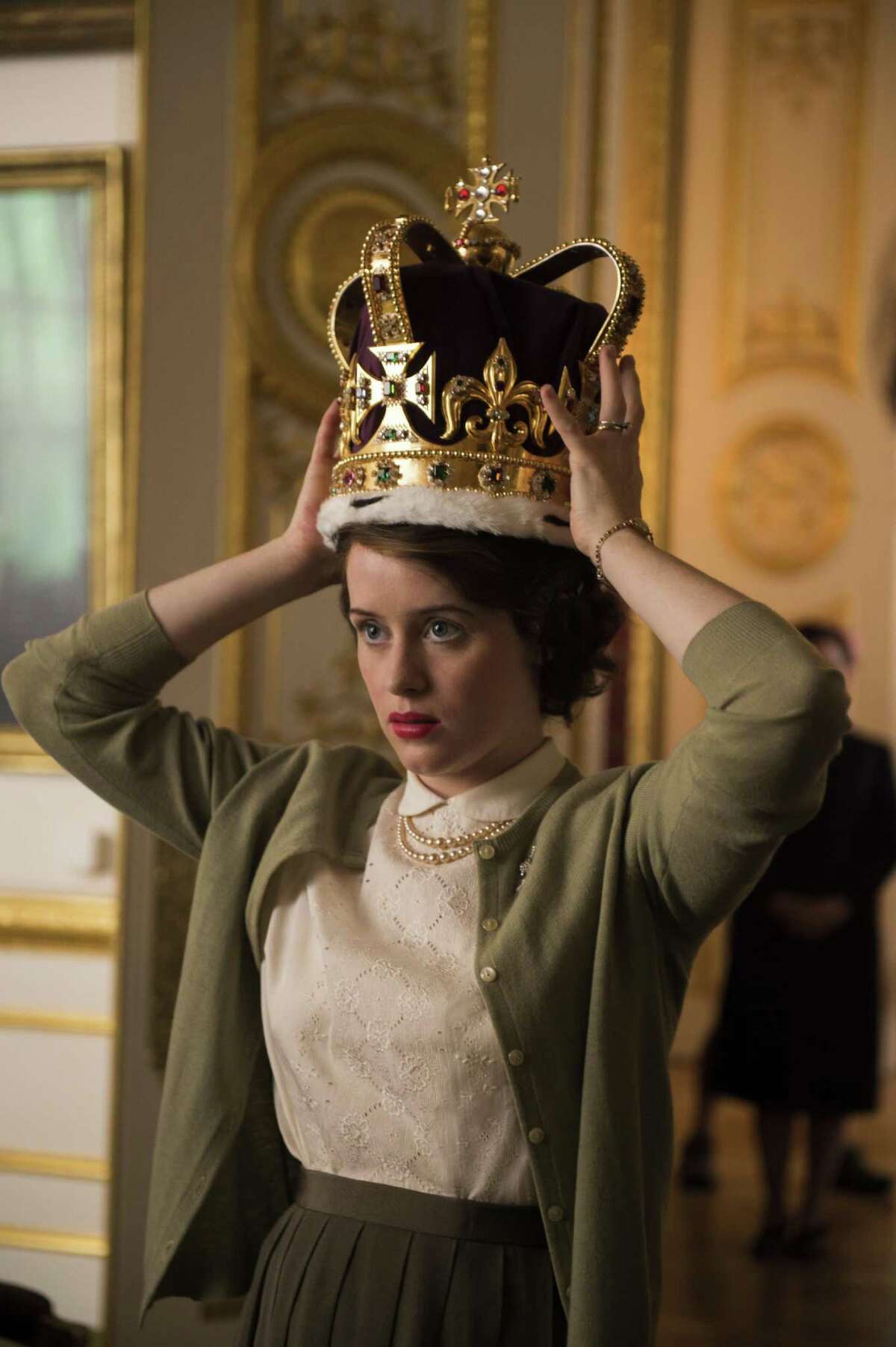 Elizabeth II (Claire Foy) practices wearing the 5-pound crown in “The Crown.”