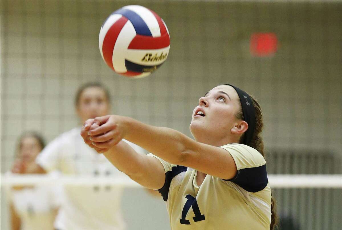O’Connor’s Allison Fields (11) returns the ball against Reagan in a nondistrict volleyball game at Littleton Gym on Aug. 18, 2015.