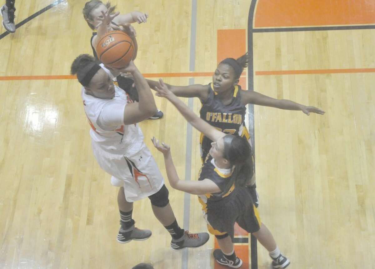 EHS senior center Emmonnie Henderson shoots a jumper over two O’Fallon defenders during the first quarter. The Tigers cruised to a 75-29 win for their 53rd straight SWC victory.