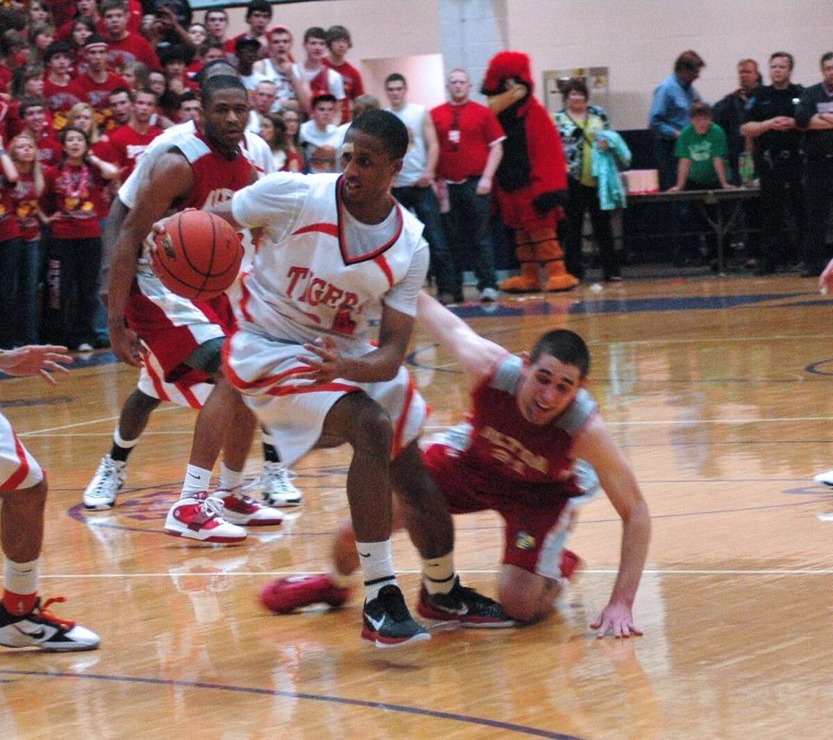 Tiger Virtis Lewis picks up a loose ball and moves past an Alton defender late in the fourth quarter.