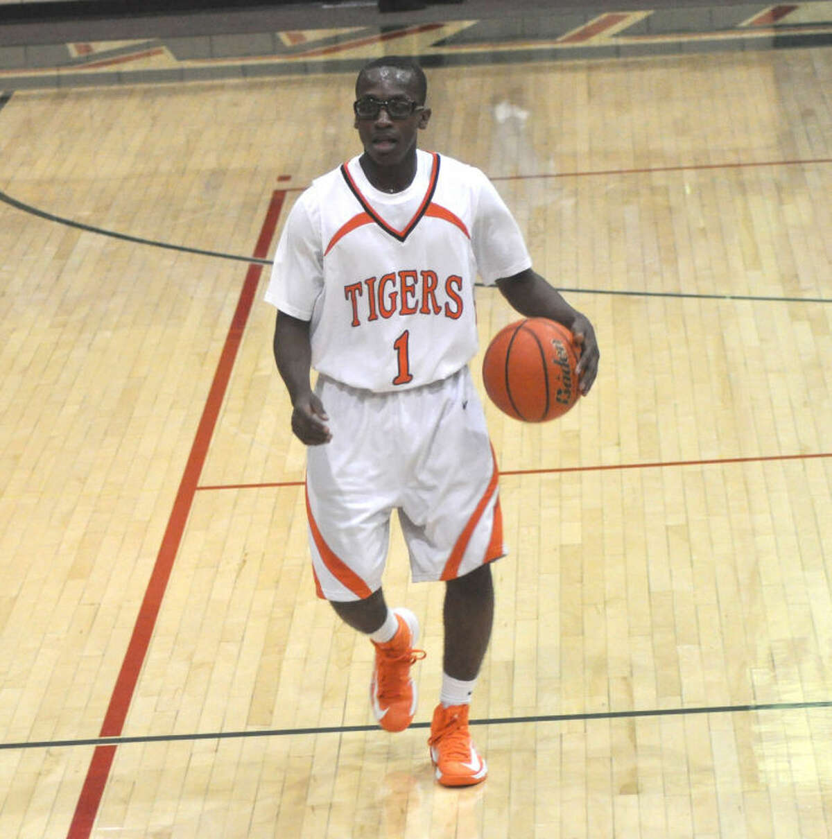 Tiger senior Jaleel Joshua brings the ball up court on Wednesday against the Green Wave.