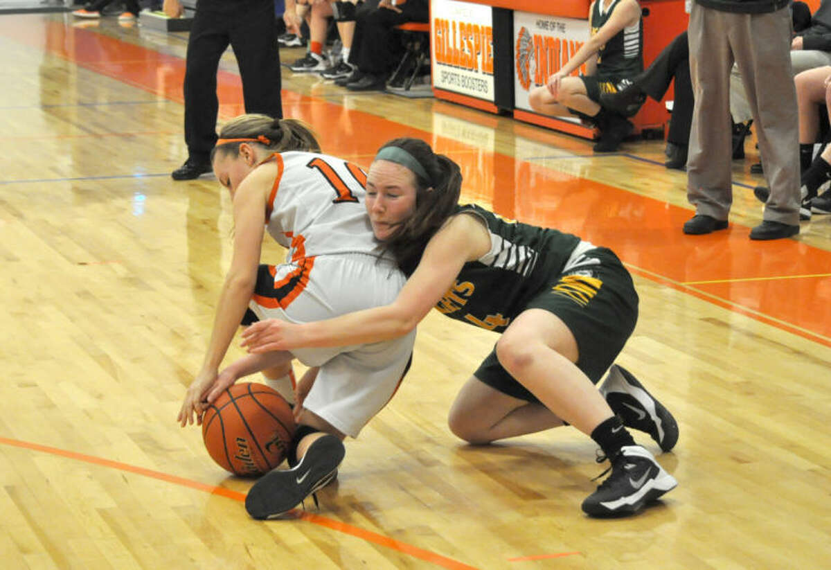 MELHS’ Abby McMahon, right, wrestles with a Gillespie player for a loose ball late in the fourth quarter on Wednesday in Gillespie.