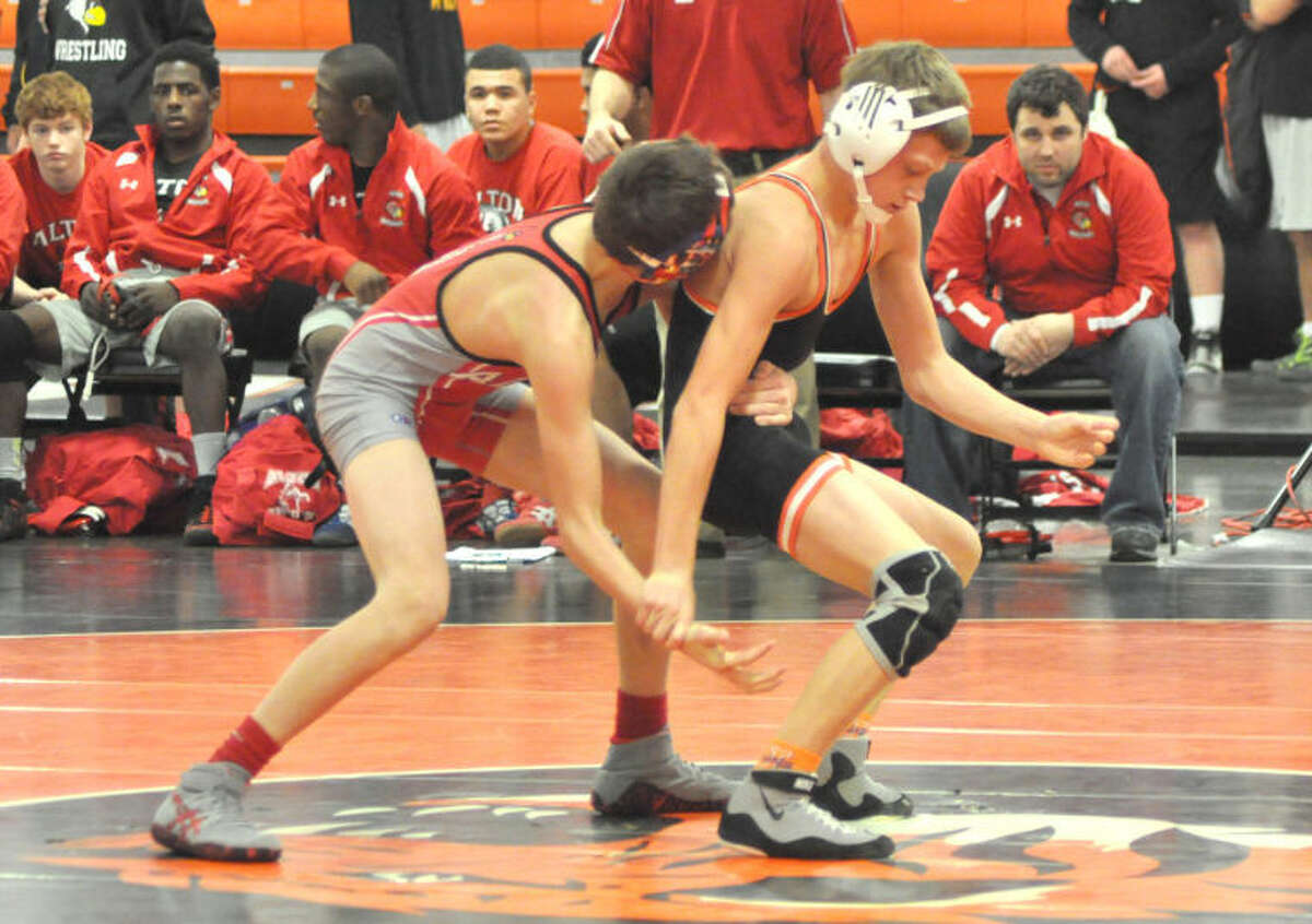 EHS’ Ben Schlueter attempts to escape from Dylan Sims of the Redbirds at 106 pounds on Thursday. Schlueter prevailed 2-0 in the match. The Tigers beat Alton 36-16 and Belleville Althoff 73-5 in the triangular.  