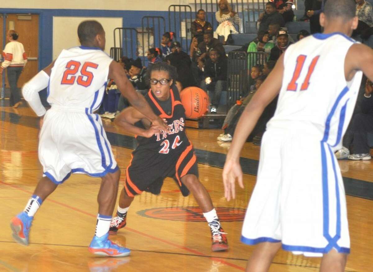 Edwardsville Tiger Shawn Roundtree (24) works against an East St. Louis defender Tuesday at East St. Louis.