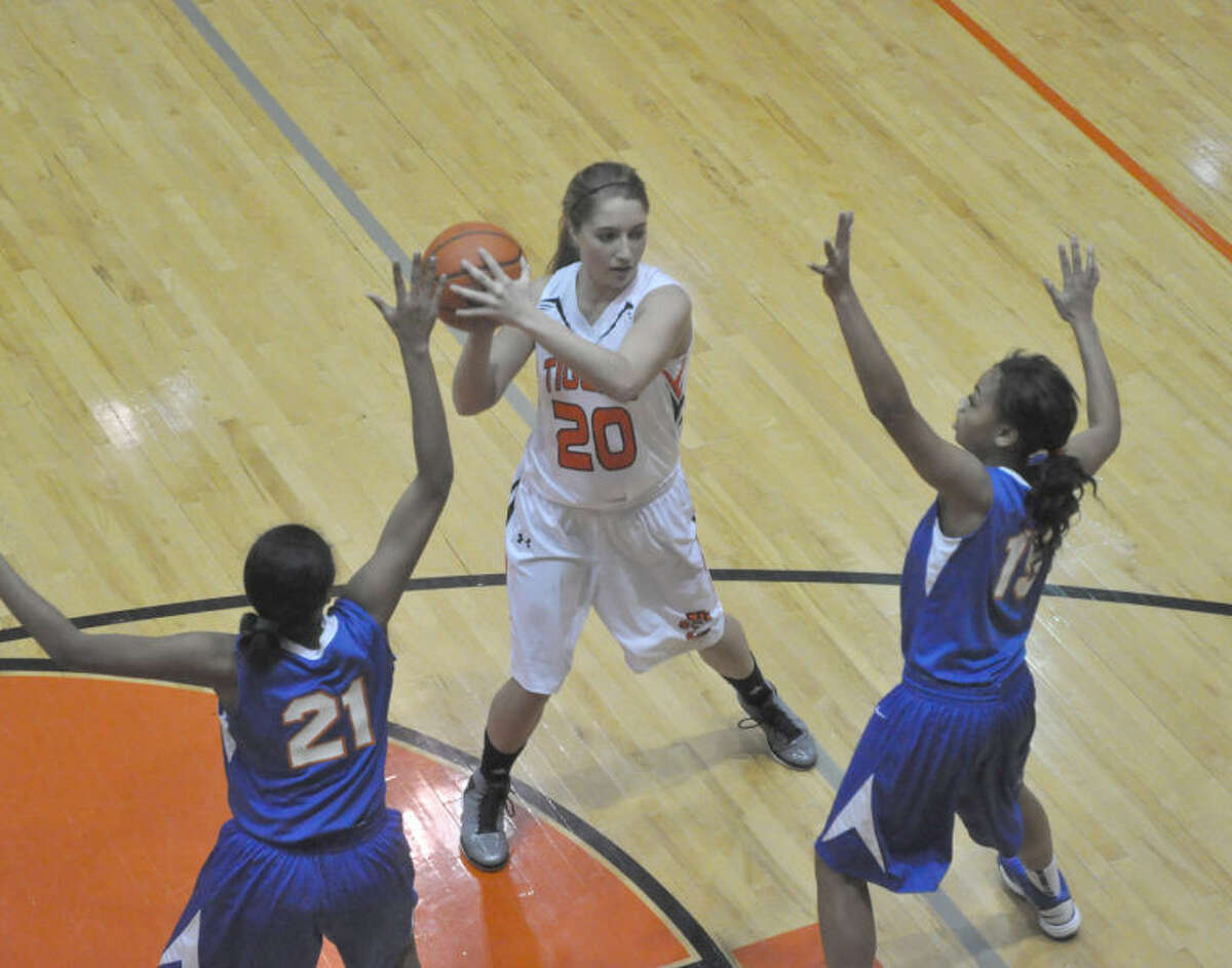 Edwardsville junior Kennedy Martin protects the ball from two East St. Louis defenders on Thursday. Martin has become the first post player off the bench for the Tigers this season.