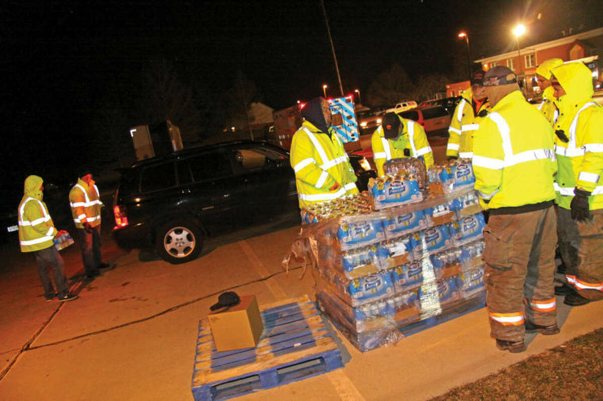 Emergency crews gathered Thursday evening behind Glen Carbon's Village Hall with drive-through stations set up. One station offered bottled water, and the other with water in containers that had not yet been boiled. It was the second night of water distribution following a major disruption in water service due to Tuesday night's water main break.