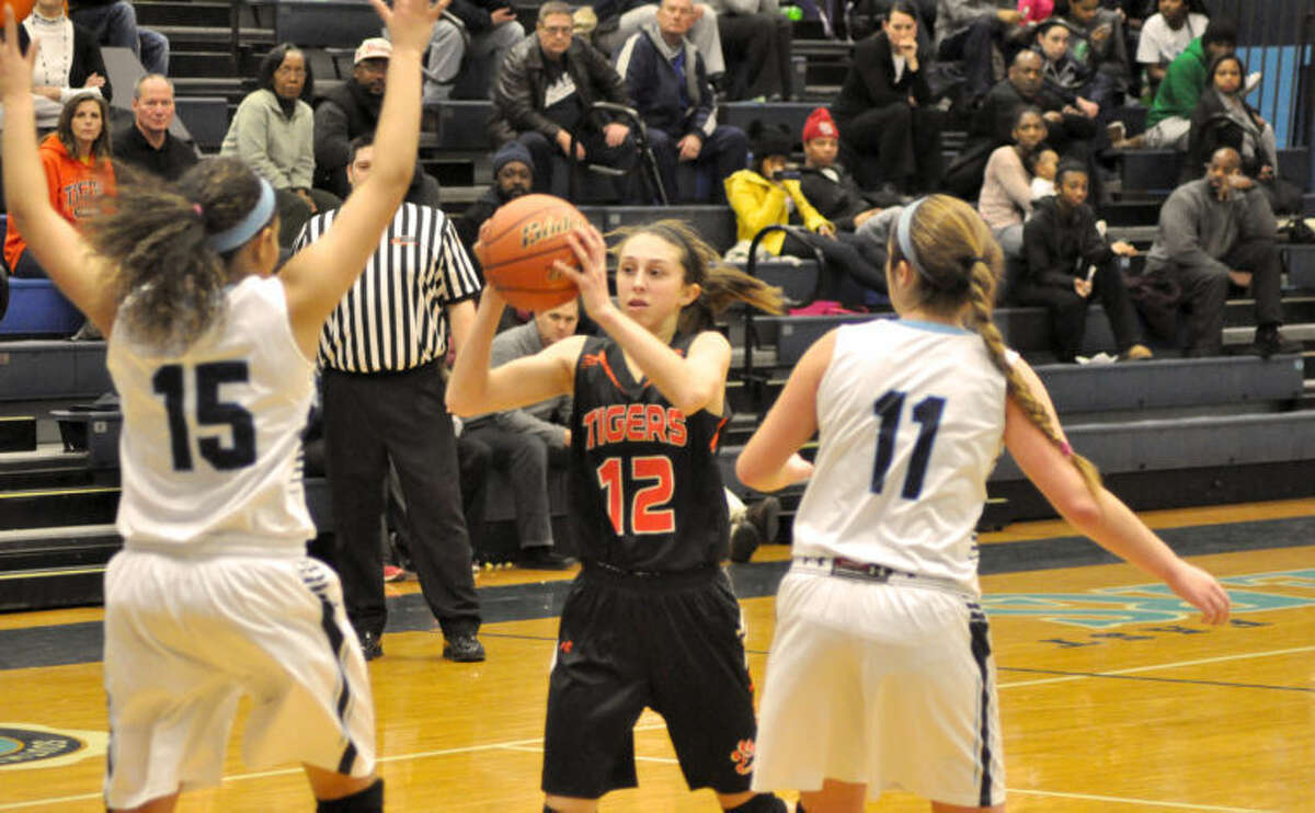 EHS’ Makenzie Silvey, center, looks to get past Belleville East’s Montira Mosby (No. 15) and Erin Holl (No. 11) during the fourth quarter. Edwardsville won 59-30 to improve to 18-1.