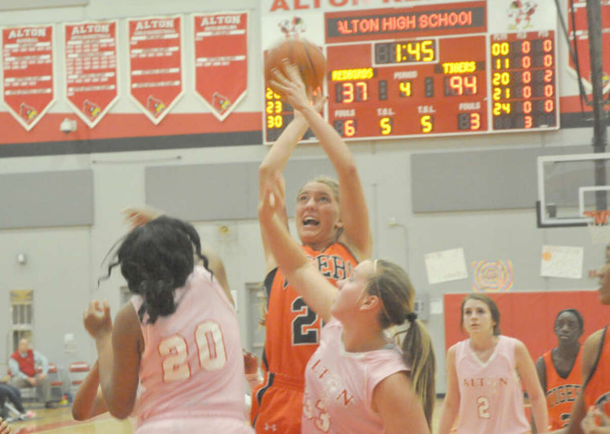 Edwardsville junior forward Kennedy Martin attempts a shot over two Alton defenders during the fourth quarter on Thursday in Alton. 