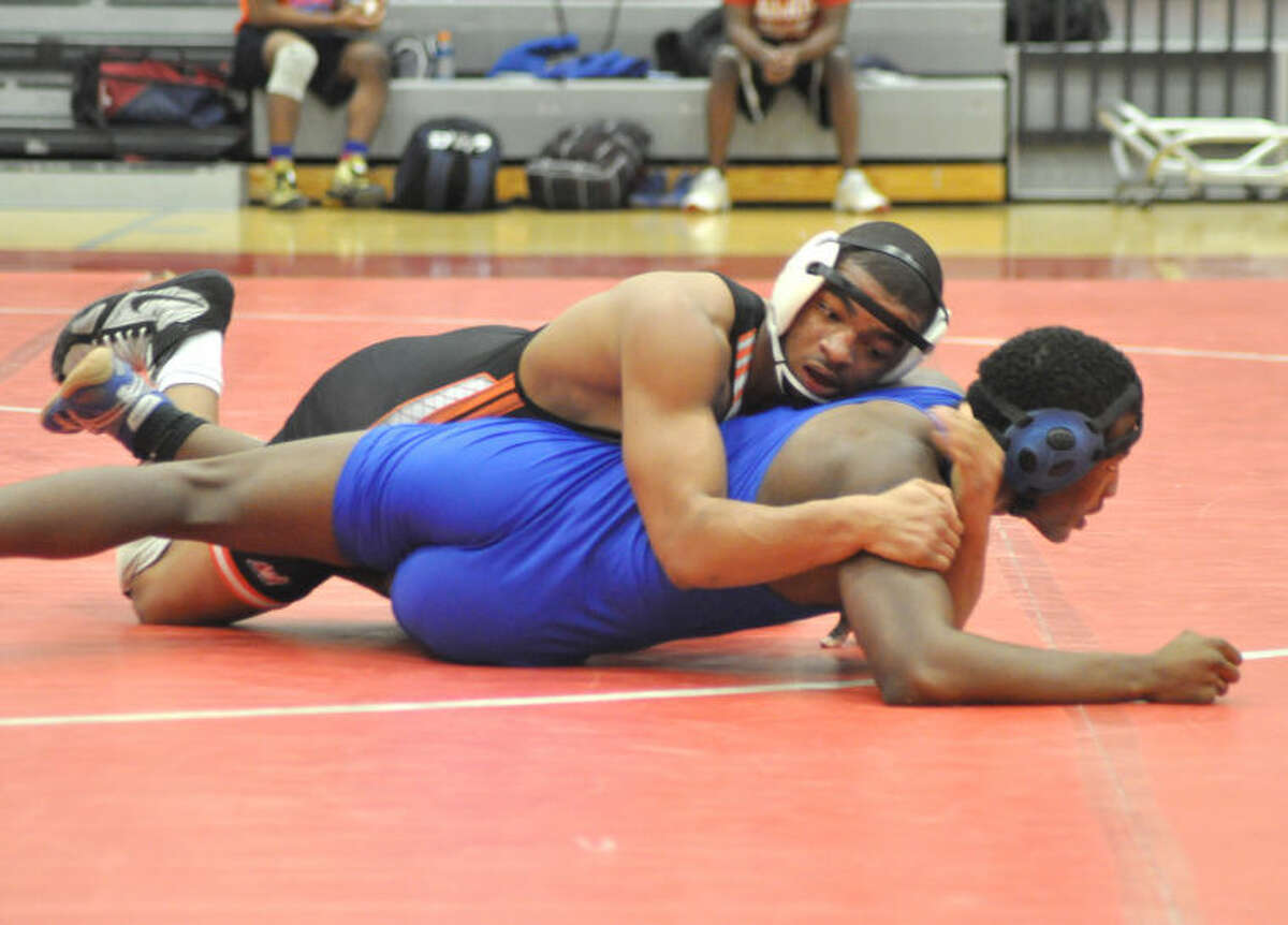 Edwardsville’s Gabe Jackson gets positioning on East St. Louis’ Keenan Scott on Thursday at Glenwood High School in Chatham. Jackson won 9-8 in the final seconds.