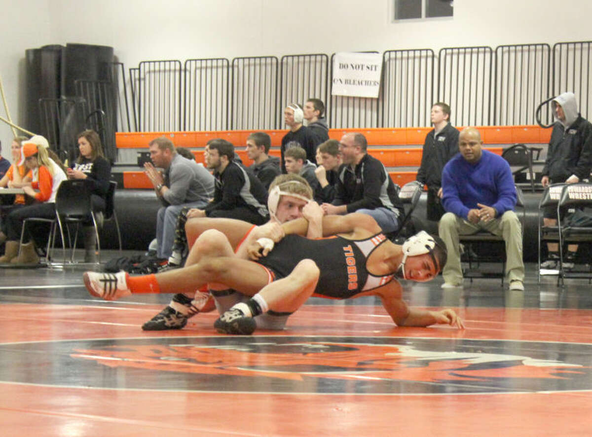Edwardsville’s Martel Evans tries to escape the grasp of Whitfield’s Derrick Swaney during a 132-pound match.