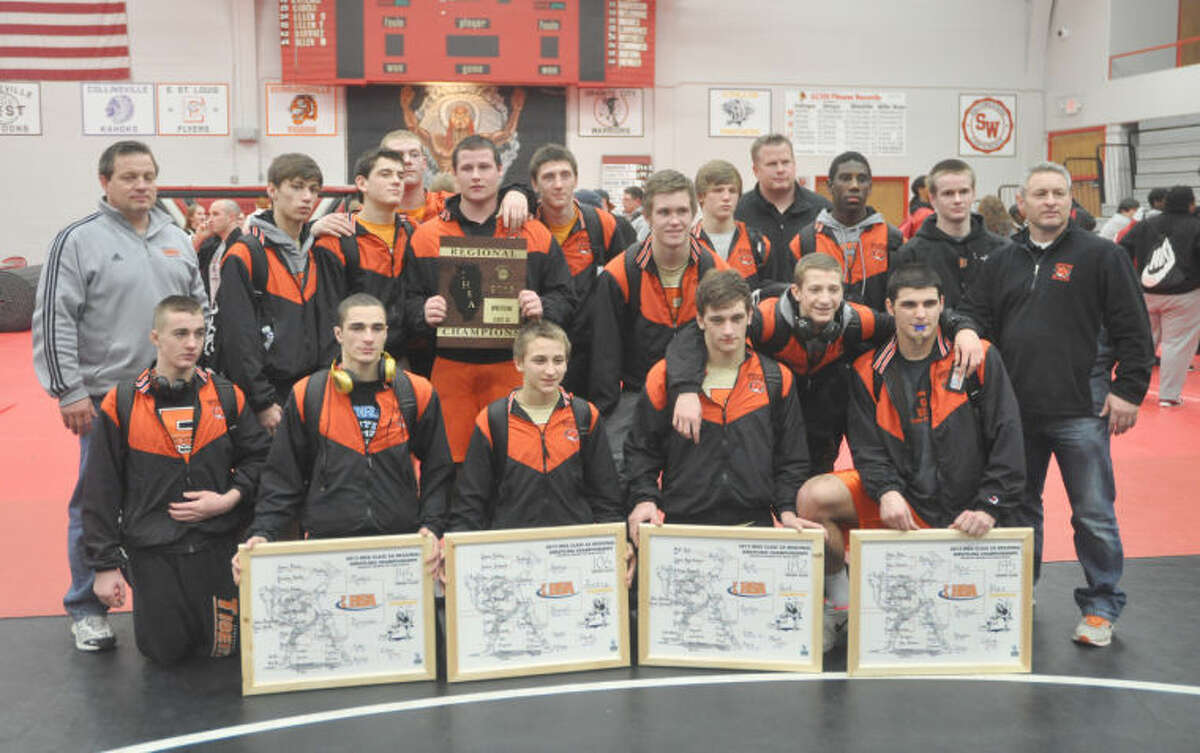 The Edwardsville Tiger wrestling team poses with their Class 3A Granite City Regional title plaque and their individual championships. As a team EHS went 25-3 in dual action and won a share of the Southwestern Conference title. 