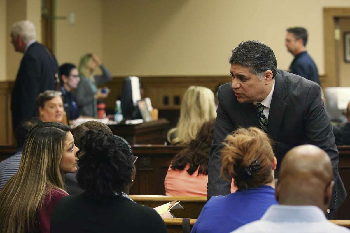 Lawyer Aric Garza talks with former Career Point College students before a hearing in their lawsuit against the college.